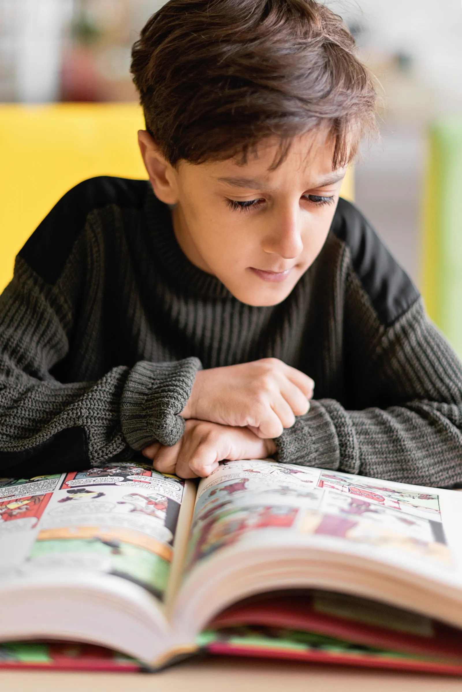 A boy deep in a book at the tutoring center